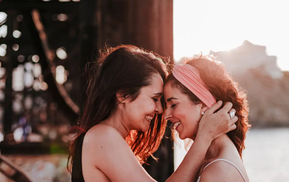 Pareja femenina sonriendo con conexión afectiva.