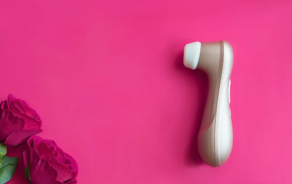 Vibrador de succión elegante sobre fondo fucsia